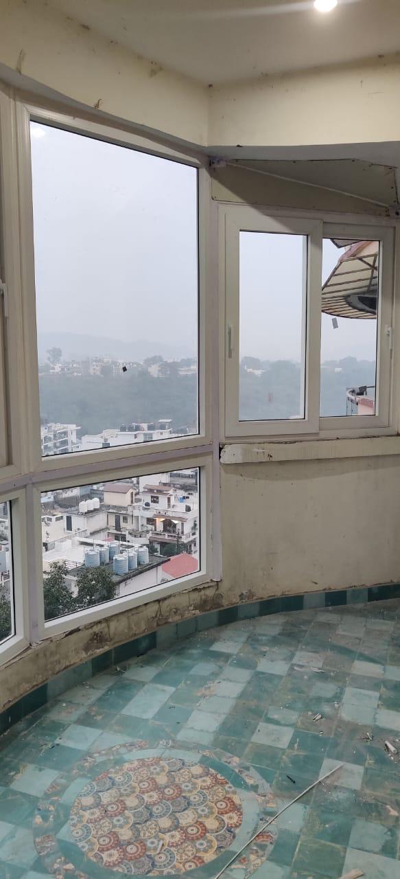 Large white framed corner windows overlooking a city