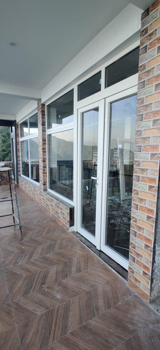 White framed glazed entrance along an exterior corridor