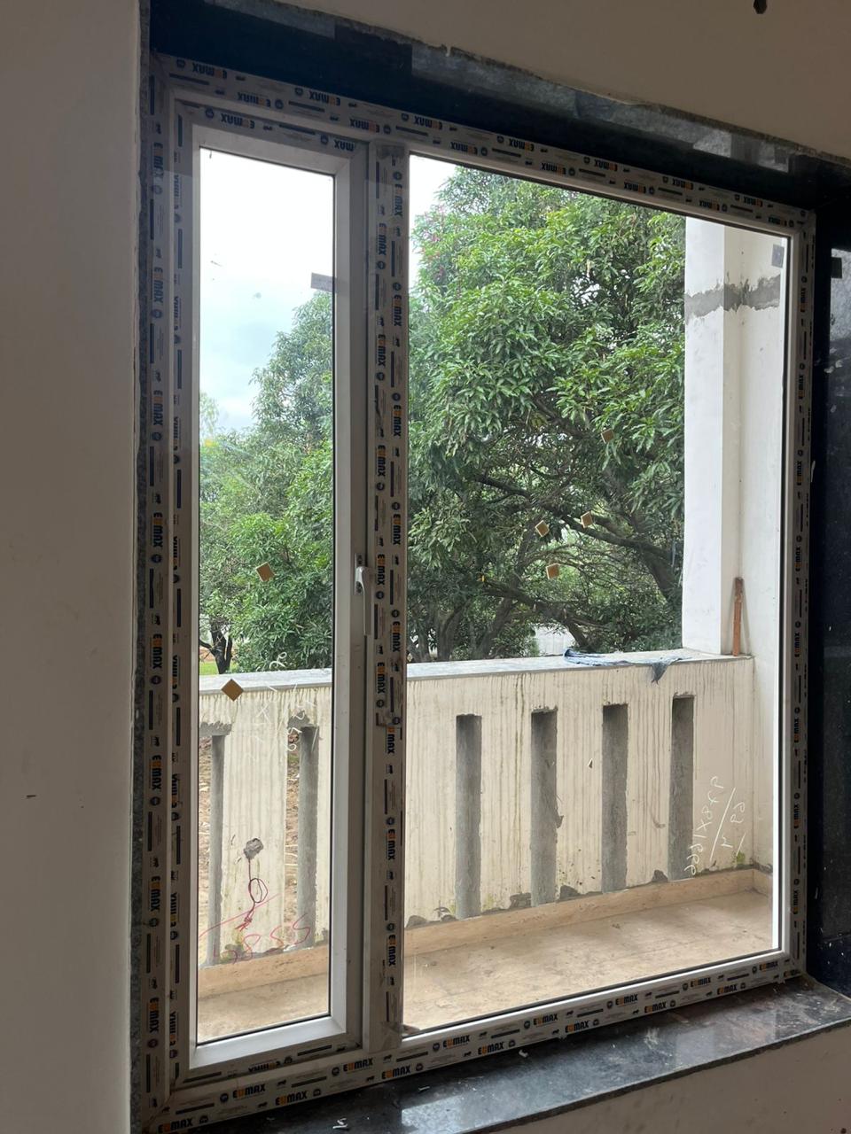 White framed window overlooking green trees